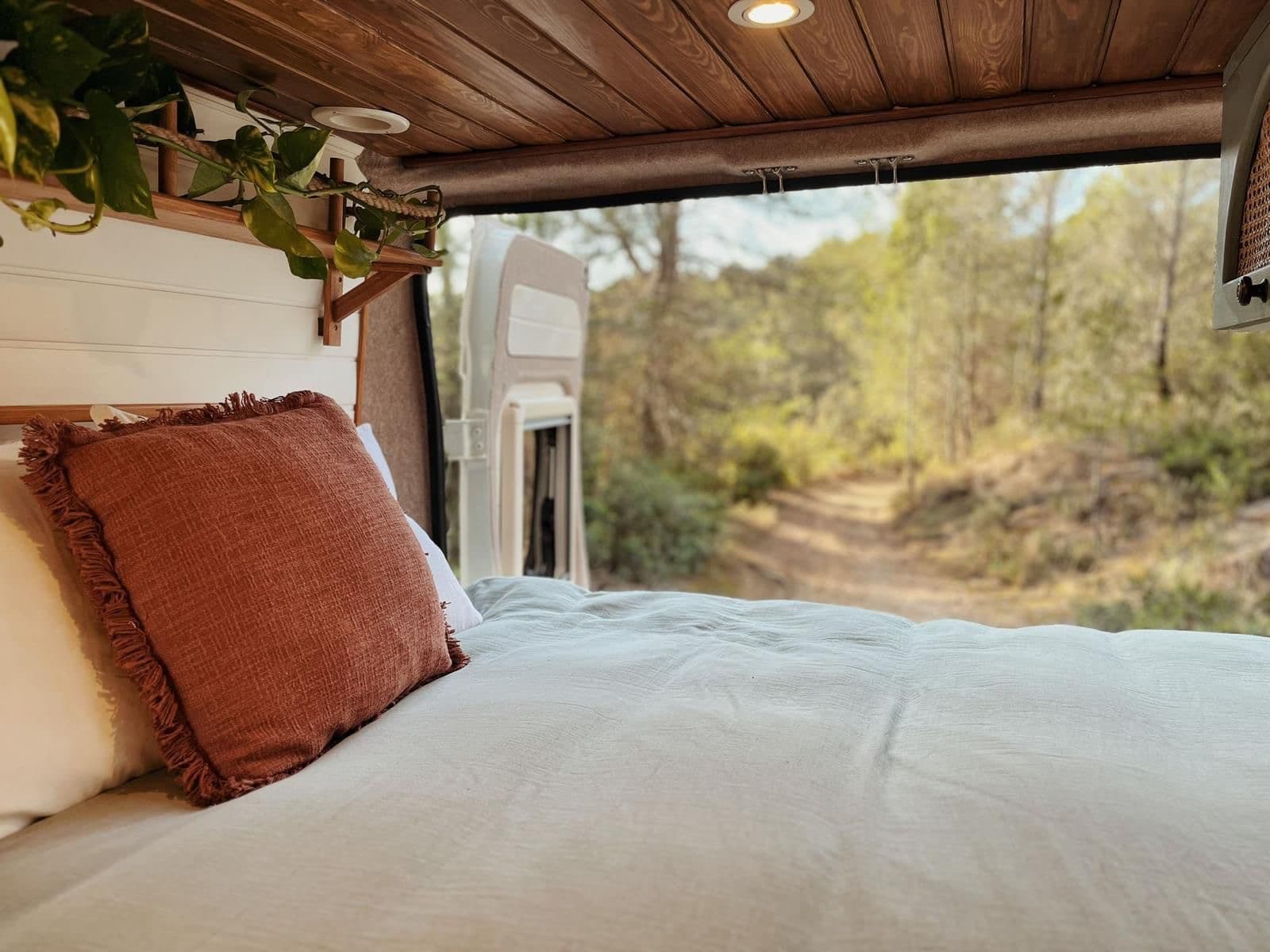 Bett mit Kissen und Blick durch die Hecktüren