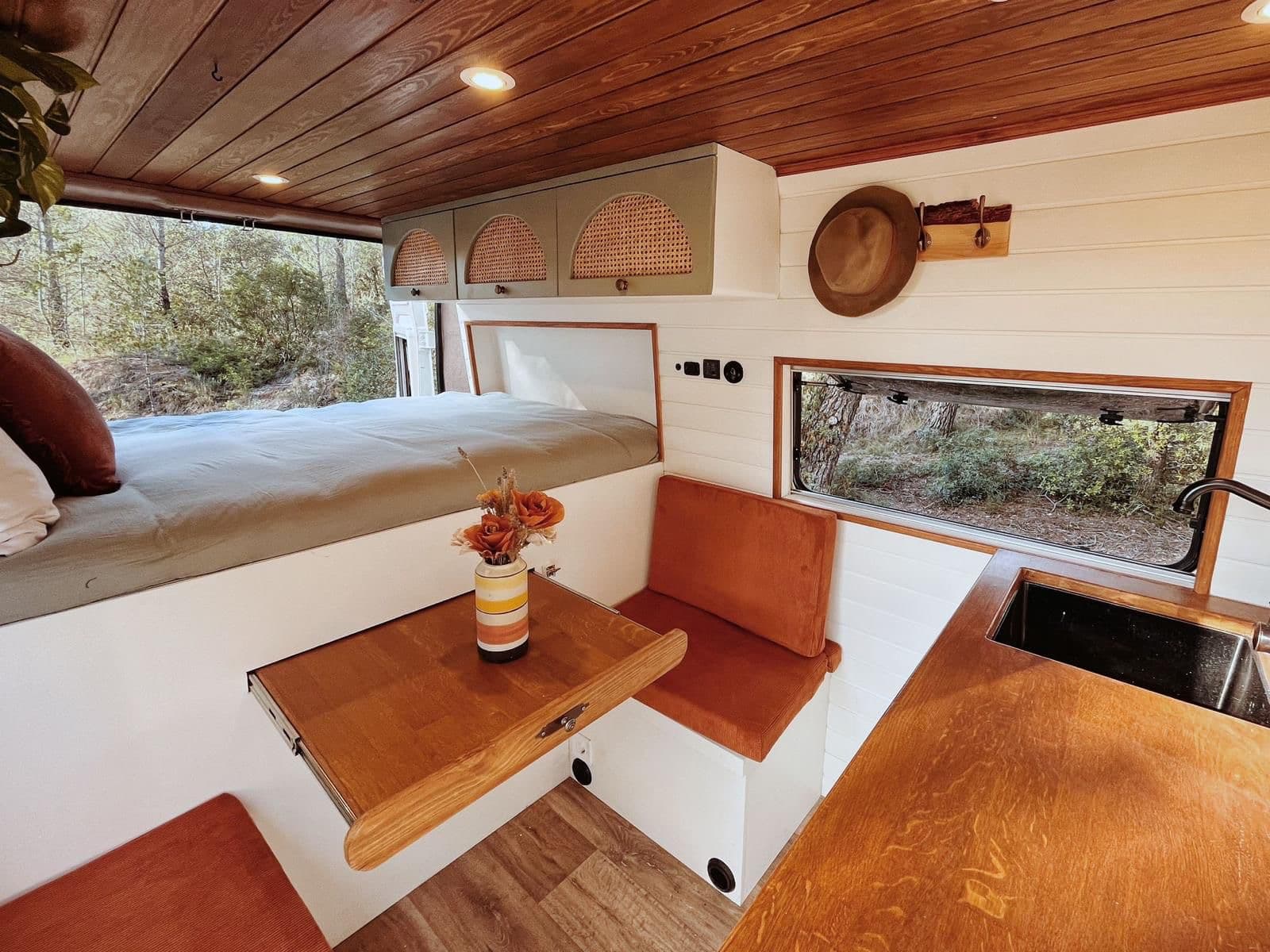 Innenraum des Campers mit Bett und Sitzecke